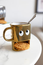 Tasse à biscuits dorés tenant un visage
