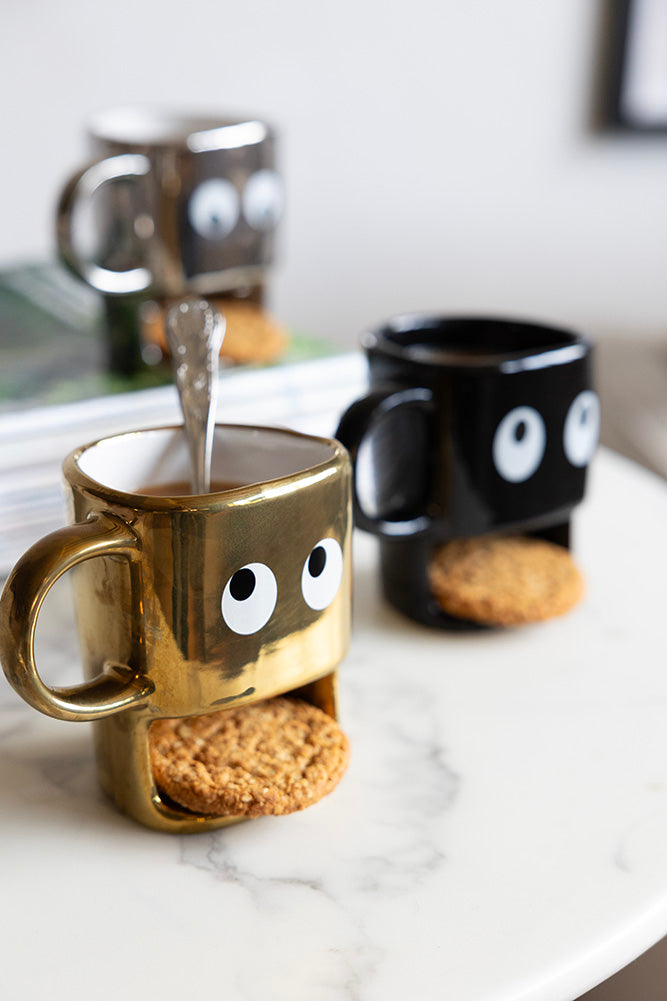 Tasse à biscuits dorés tenant un visage